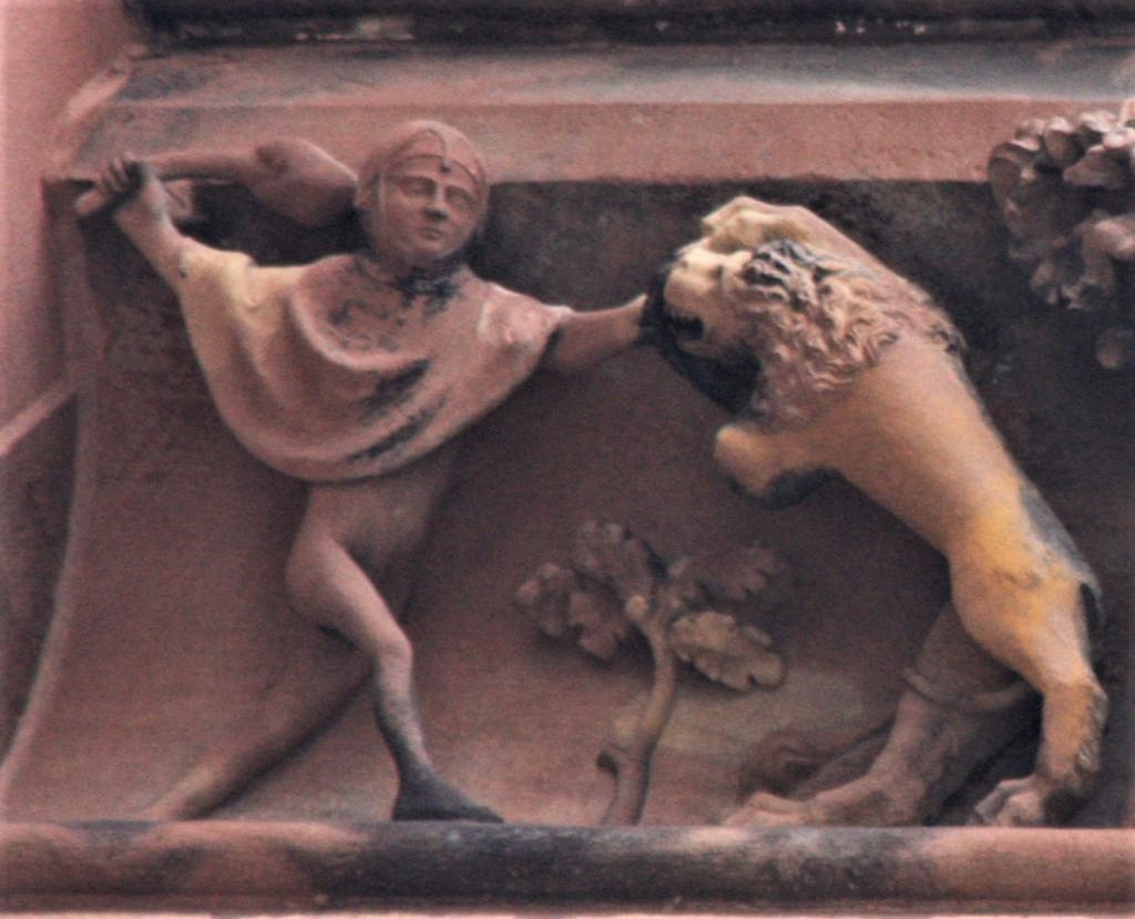 ein halbnackter Mensch kaempft gegen einen Loewen; Detail aus dem Fries am Nordturms der Cathedrale de Strasbourg