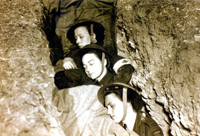 Dorothy Mulholland mit zwei Kolleginnen vom kanadischen Schwesternkorps, die sich in einem Schuetzengraben ausruhen.