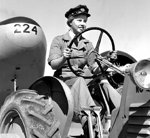 Laura Bagby von der Royal Canadian Air Force Women's Division am Steuer ihres Traktors, der ein Flugzeug zieht,