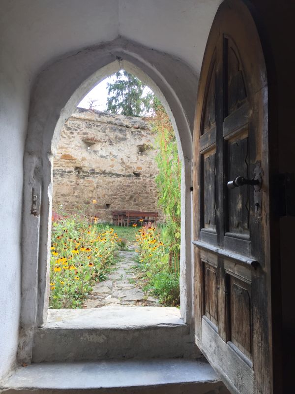 Blick aus dem Suedeingang der Wehrkirche in Kleinschenk / Cincsor auf den Kirchhof