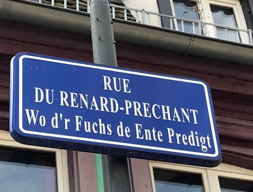 zweisprachiges Straßenschild in Strassburg; Rue du Renard-Prêchant - Wo d'r Fuchs de Ente Predigt